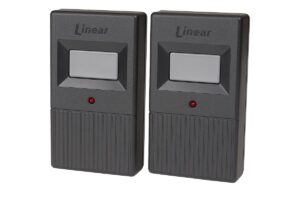 Two Linear MegaCode MT-1B garage remotes side by side, each with a single gray button and red LED.