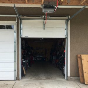 Black metal garage door hardware accents including decorative handles and hinge straps.
