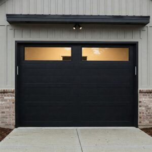  Contemporary black garage door with windows on the top panel, set against a light gray building.