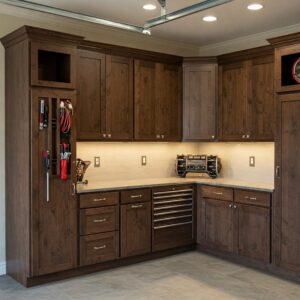 New age garage cabinets in dark wood finish with neatly organized tools and built-in lighting.