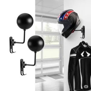 A product-focused image of two black spherical wall-mounted metal helmet holders. One holder displays a black and white motorcycle helmet with a star and stripe design, and a black, yellow, and white motorcycle jacket hangs below. Installation accessories are neatly arranged on the white background, offering a practical solution for armor and helmet storage
