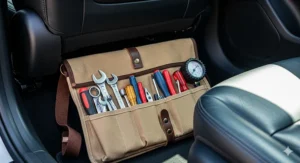 A roll up tool bag stored neatly under the seat of a car, demonstrating its practicality for on-the-go storage and emergency repairs.