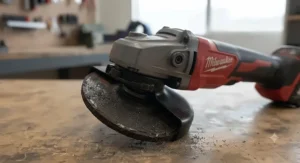 Close-up view of an angle grinder equipped with a thick abrasive grinding wheel.